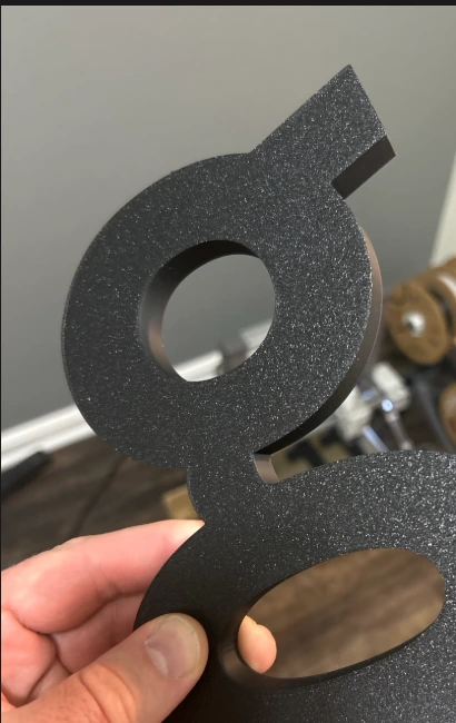 Close-up of a textured black 3D letter produced for the Willow project